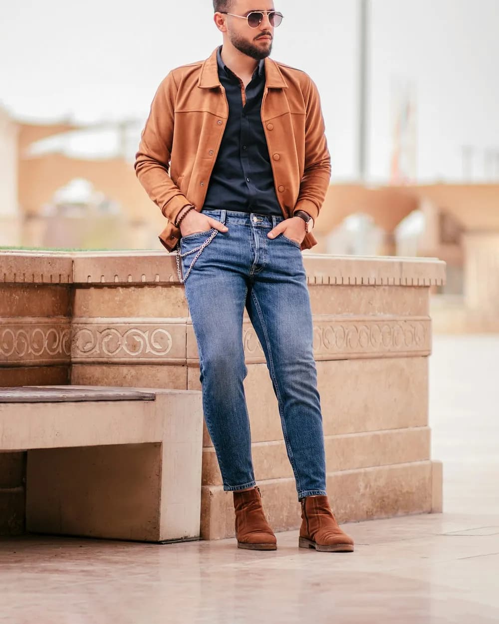 A man in a tan suede jacket and jeans