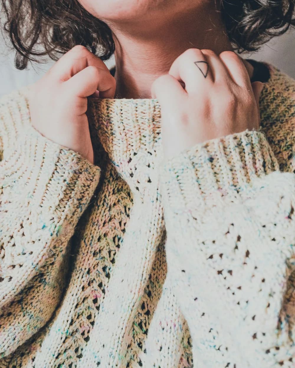 A woman in an oatmeal open-knit sweater